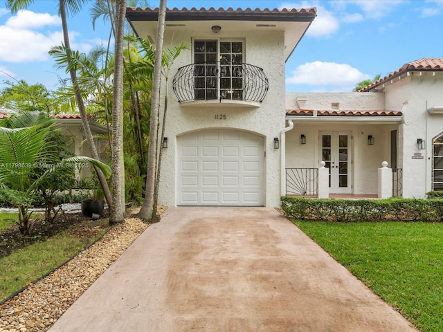 1125 Asturia Ave, Coral Gables, FL 33134 - mediterranean / spanish house featuring a garage, stucco siding, french doors, concrete driveway, and a tiled roof