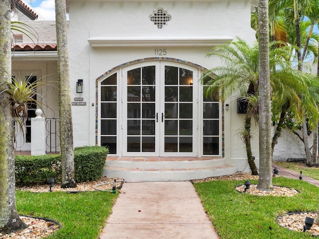 1125 Asturia Ave, Coral Gables, FL 33134 - view of exterior entry featuring french doors, stucco siding, and a tiled roof