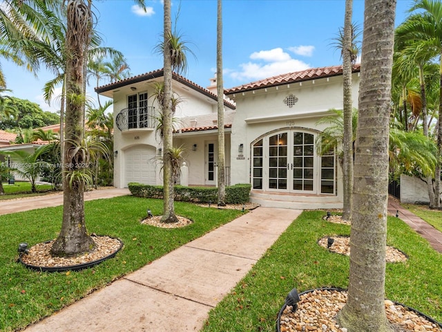 1125 Asturia Ave, Coral Gables, FL 33134 - mediterranean / spanish-style house featuring french doors, a tile roof, stucco siding, a front lawn, and a balcony