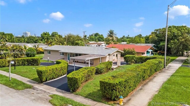 1900 NE 180th St, North Miami Beach, FL 33162 - view of front of property with asphalt driveway, a front yard, and a carport