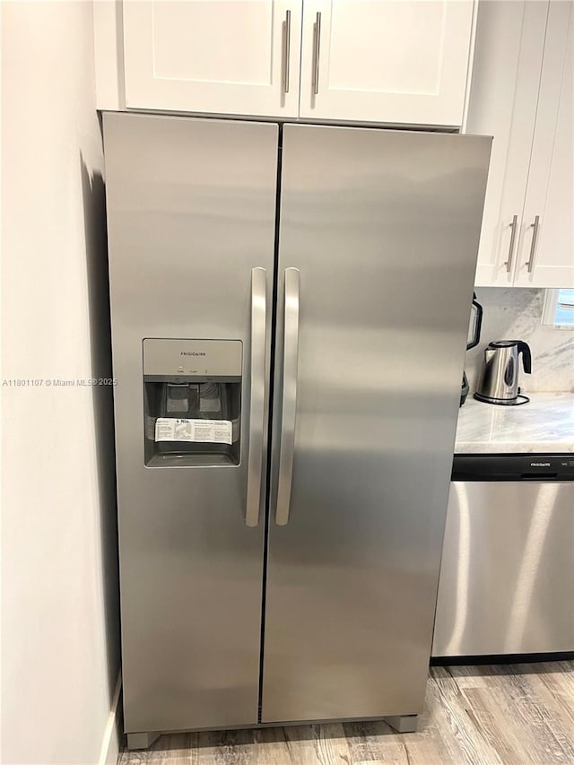 1900 NE 180th St, North Miami Beach, FL 33162 - kitchen view of appliances with stainless steel finishes, white cabinets, and light wood finished floors