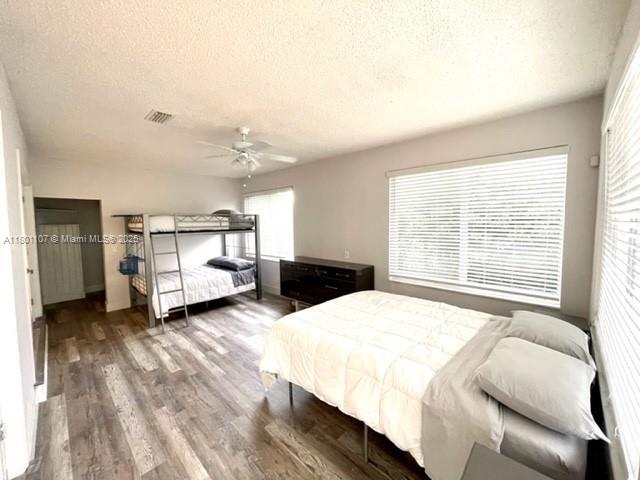 1900 NE 180th St, North Miami Beach, FL 33162 - bedroom featuring a textured ceiling, wood finished floors, and a ceiling fan
