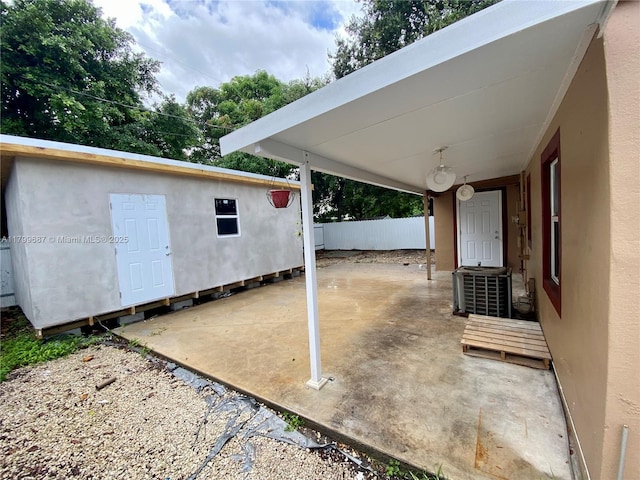 view of patio / terrace featuring fence and an outbuilding