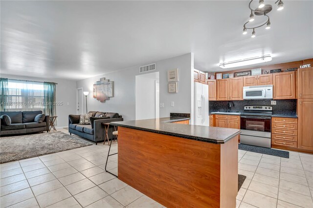 9020 NE 8th Ave Unit 2A, Miami Shores, FL 33138 - kitchen with white appliances, a sink, dark countertops, and light tile patterned floors