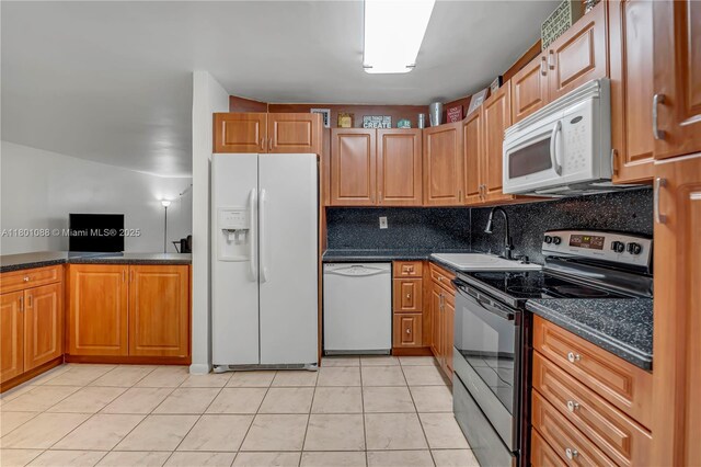 9020 NE 8th Ave Unit 2A, Miami Shores, FL 33138 - kitchen featuring white appliances, a sink, dark countertops, and backsplash