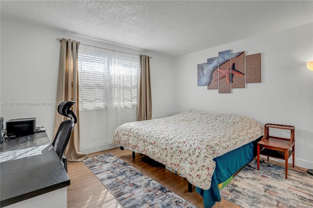 9020 NE 8th Ave Unit 2A, Miami Shores, FL 33138 - bedroom with a textured ceiling, wood finished floors, and an office area