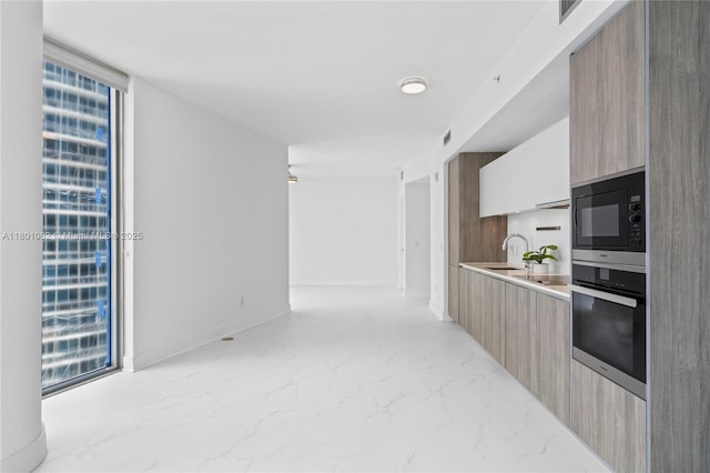 2900 NE 7th Ave Unit 1409, Miami, FL 33137 - kitchen with modern cabinets, wall oven, built in microwave, light marble finish floors, and light countertops