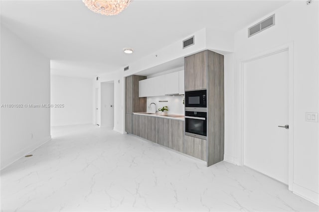 2900 NE 7th Ave Unit 1409, Miami, FL 33137 - kitchen with stainless steel oven, black microwave, modern cabinets, and light marble finish flooring