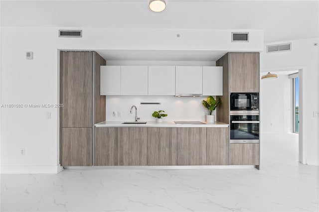 2900 NE 7th Ave Unit 1409, Miami, FL 33137 - kitchen featuring black appliances, light marble finish floors, modern cabinets, and light countertops