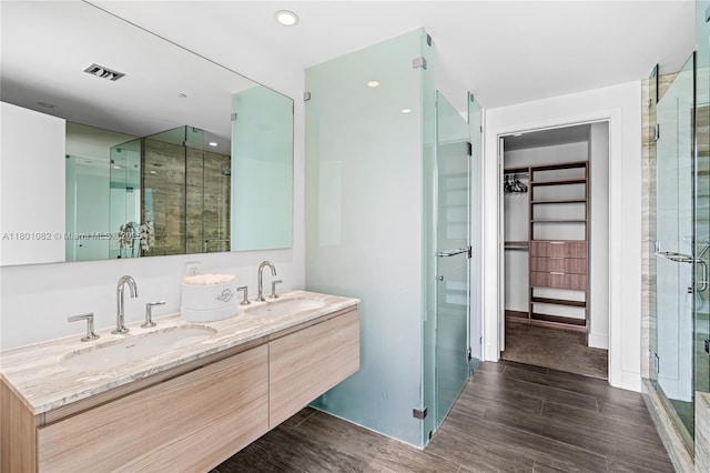 2900 NE 7th Ave Unit 1409, Miami, FL 33137 - full bathroom with a spacious closet, double vanity, wood finished floors, a shower stall, and recessed lighting