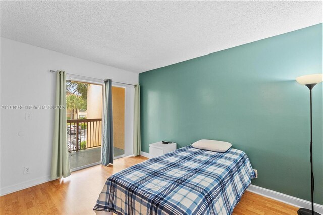 7620 Westwood Dr Unit 216, Tamarac, FL 33321 - bedroom with access to outside, wood finished floors, a textured ceiling, and baseboards