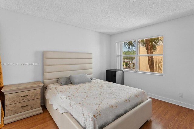 7620 Westwood Dr Unit 216, Tamarac, FL 33321 - bedroom with wood finished floors, a textured ceiling, and baseboards