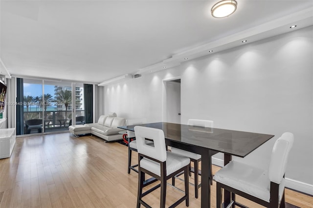 5700 Collins Ave Unit 4A, Miami Beach, FL 33140 - dining room featuring light wood-style floors, a wall of windows, and recessed lighting