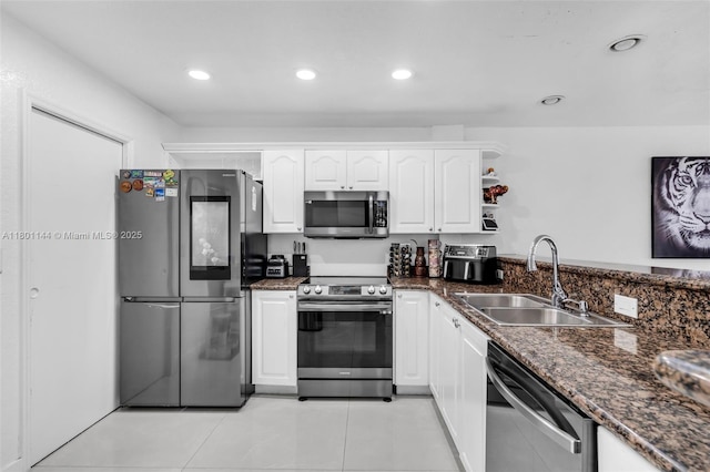 6306 Moseley St Unit 1, Hollywood, FL 33024 - kitchen featuring appliances with stainless steel finishes, a sink, white cabinets, light tile patterned flooring, and dark stone countertops