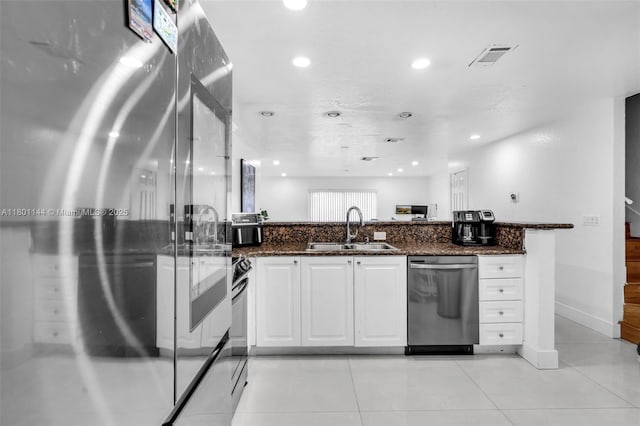 6306 Moseley St Unit 1, Hollywood, FL 33024 - kitchen with appliances with stainless steel finishes, a sink, white cabinetry, dark stone countertops, and recessed lighting