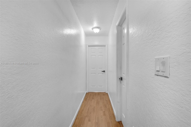 6306 Moseley St Unit 1, Hollywood, FL 33024 - hallway with a textured wall, wood finished floors, and baseboards