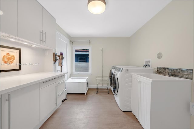 5550 N Bayshore Dr, Miami, FL 33137 - washroom with separate washer and dryer, cabinet space, and light wood-type flooring