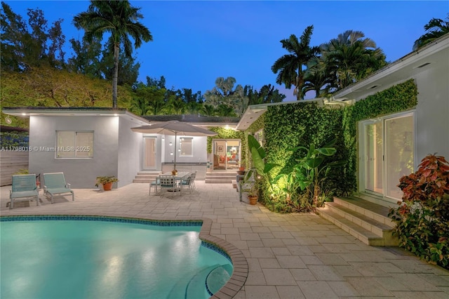 5550 N Bayshore Dr, Miami, FL 33137 - pool at twilight featuring entry steps, a patio, and an outdoor pool