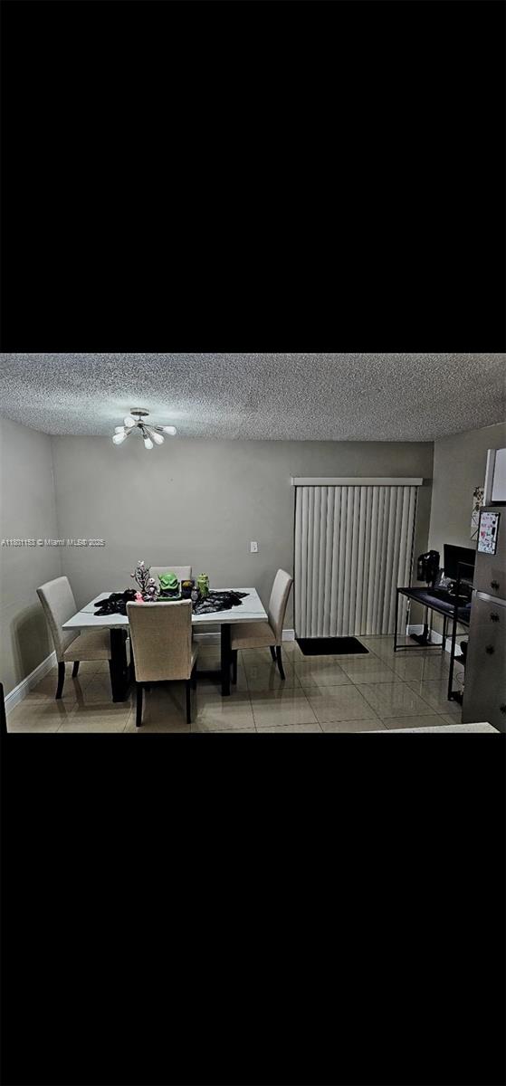 8389 NW 8th St, Miami, FL 33126 - dining space with a textured ceiling and a chandelier