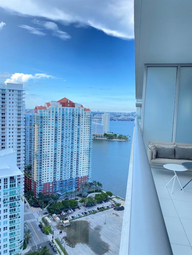 balcony with a water view and a view of city