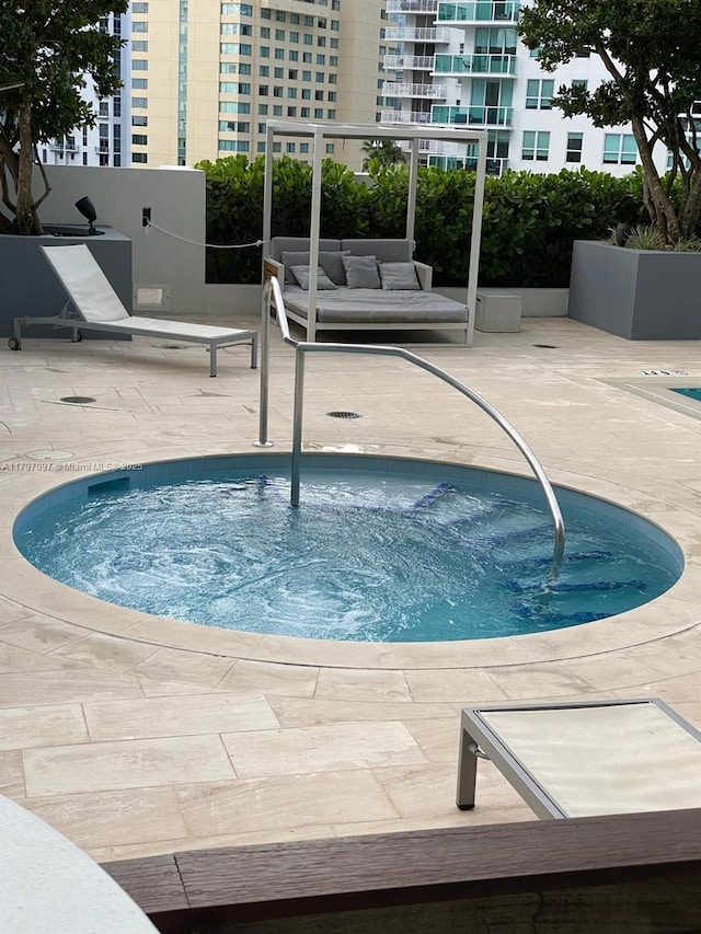 view of pool featuring a community hot tub and a patio area