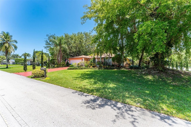 8620 SW 181st St, Palmetto Bay, FL 33157 - view of front facade with a front lawn, an attached garage, and concrete driveway