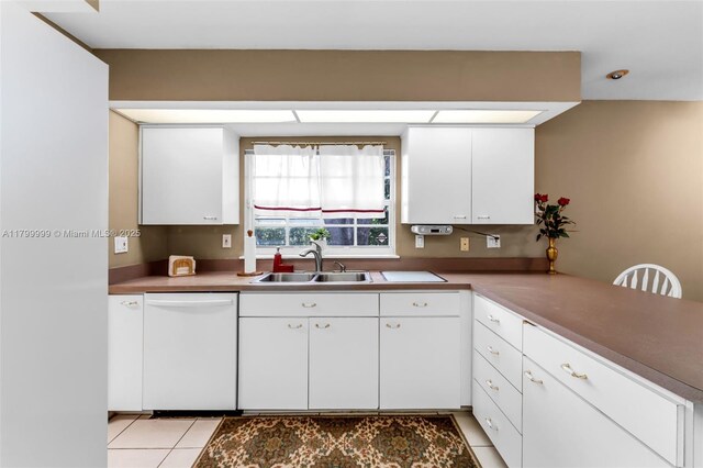 8620 SW 181st St, Palmetto Bay, FL 33157 - kitchen with dishwasher, a sink, a peninsula, light tile patterned floors, and white cabinetry