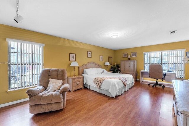 8620 SW 181st St, Palmetto Bay, FL 33157 - bedroom with light wood-style floors, baseboards, and track lighting
