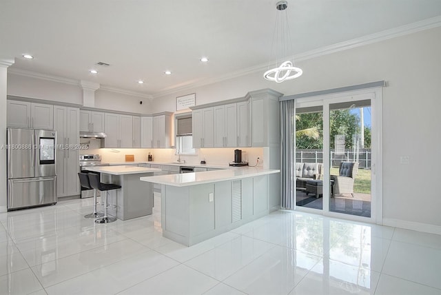 kitchen featuring stainless steel appliances, a breakfast bar, light tile patterned floors, crown molding, and light countertops