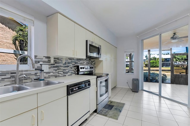 23158 Island Vw Unit 1, Boca Raton, FL 33433 - kitchen featuring appliances with stainless steel finishes, a sink, decorative backsplash, light countertops, and light tile patterned floors