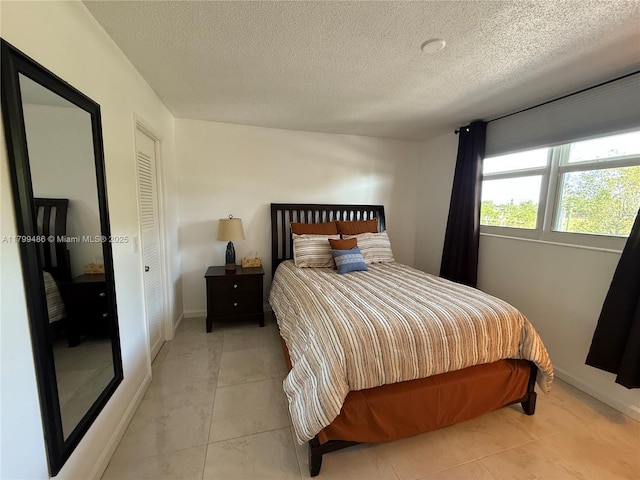 400 SE 10th St Unit 214, Deerfield Beach, FL 33441 - bedroom featuring a textured ceiling and baseboards