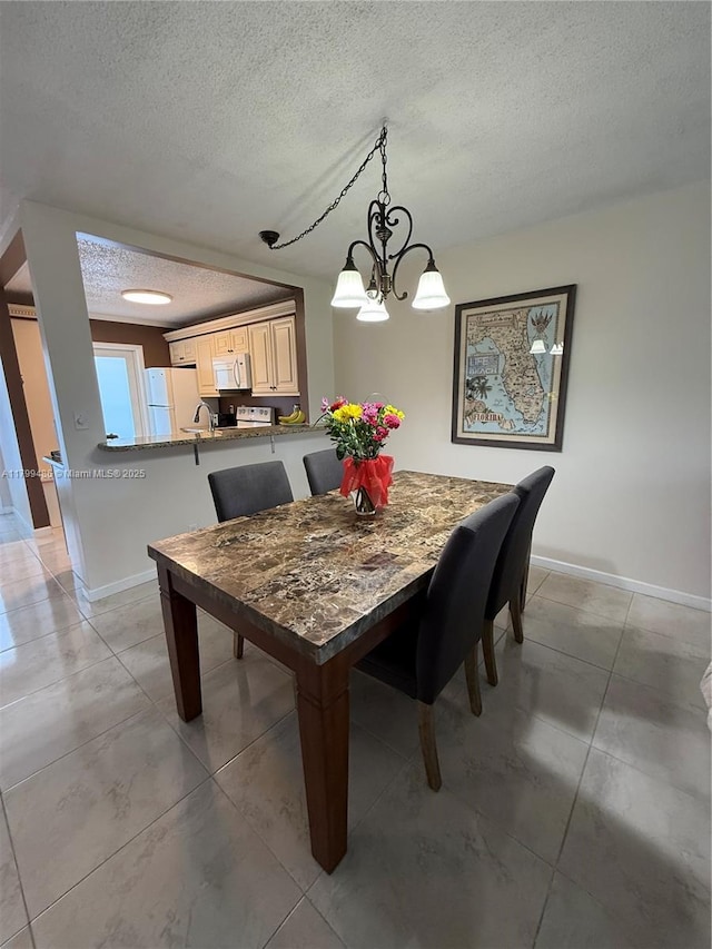 400 SE 10th St Unit 214, Deerfield Beach, FL 33441 - dining room featuring a textured ceiling, baseboards, a chandelier, and light tile patterned floors