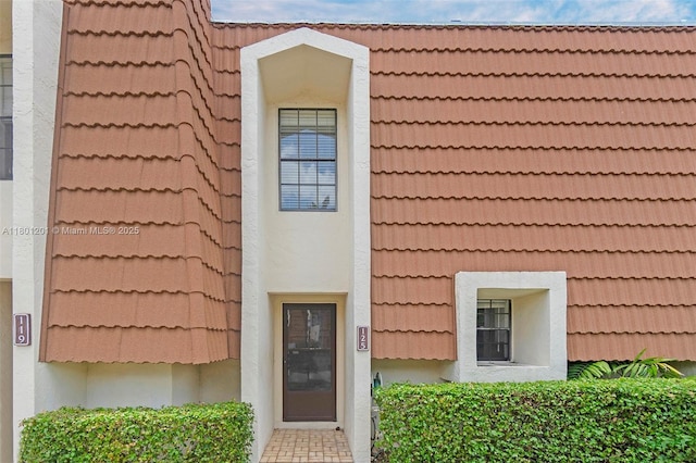 doorway to property featuring a tile roof