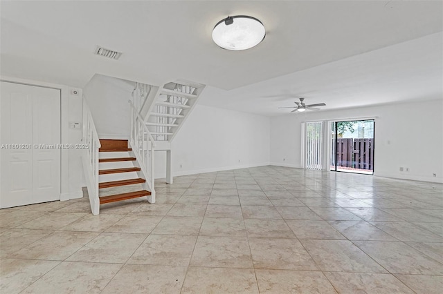 unfurnished living room featuring stairs, a ceiling fan, baseboards, and light tile patterned flooring