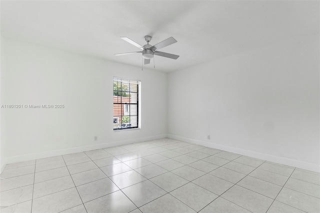 unfurnished room with ceiling fan, light tile patterned floors, and baseboards