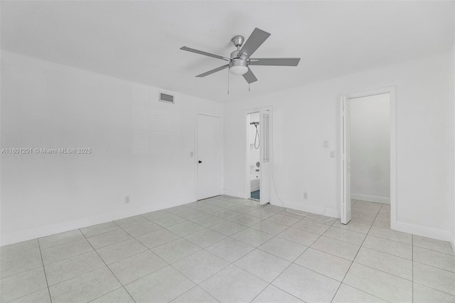 unfurnished room with a ceiling fan, light tile patterned flooring, and baseboards