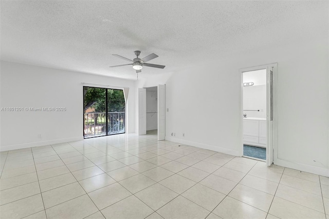 empty room featuring light tile patterned flooring, a textured ceiling, a ceiling fan, and baseboards