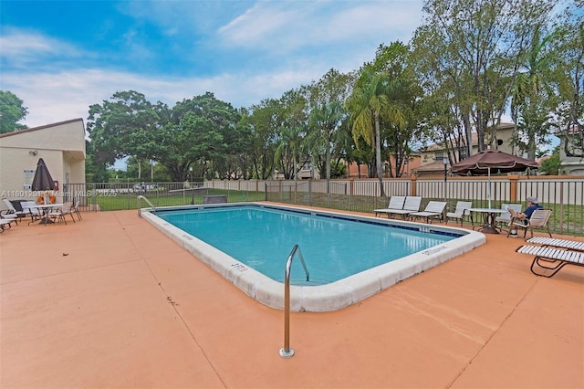 community pool with fence and a patio