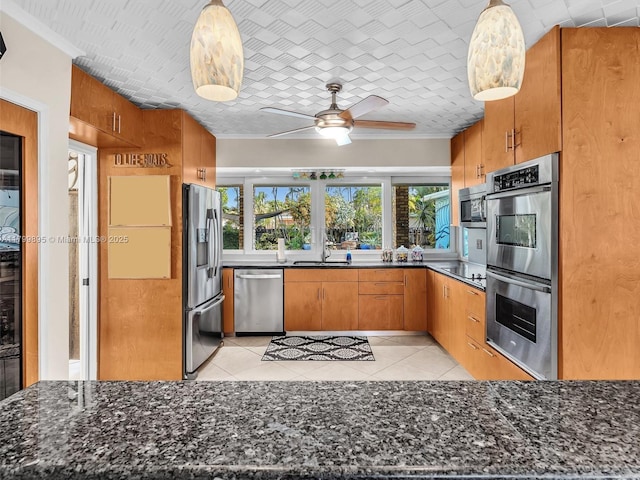 5119 Hayes St, Hollywood, FL 33021 - kitchen with appliances with stainless steel finishes, a ceiling fan, brown cabinetry, light tile patterned floors, and ornamental molding