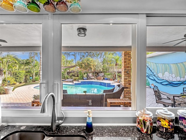 5119 Hayes St, Hollywood, FL 33021 - kitchen view of a sink, dark stone counters, and a swimming pool