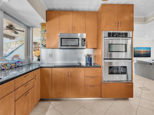 5119 Hayes St, Hollywood, FL 33021 - kitchen featuring stainless steel appliances, dark stone counters, light tile patterned flooring, crown molding, and ceiling fan