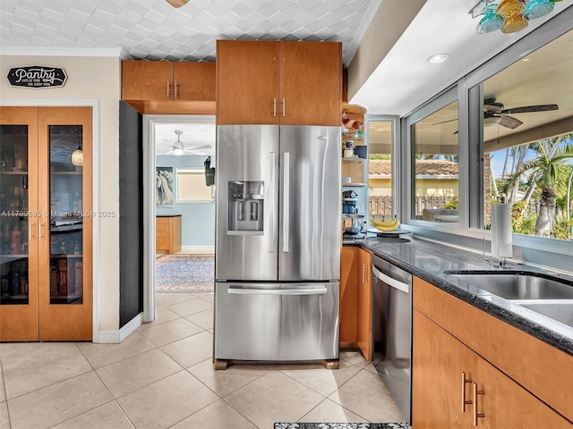 5119 Hayes St, Hollywood, FL 33021 - kitchen with stainless steel appliances, a ceiling fan, light tile patterned floors, dark stone countertops, and ornamental molding