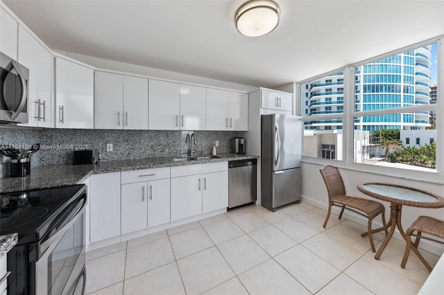 2751 S Ocean Dr Unit 403S, Hollywood, FL 33019 - kitchen featuring appliances with stainless steel finishes, a sink, dark stone countertops, tasteful backsplash, and white cabinetry