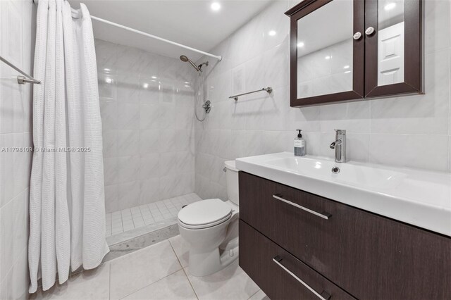 2751 S Ocean Dr Unit 403S, Hollywood, FL 33019 - bathroom with tile walls, vanity, tiled shower, toilet, and tile patterned floors
