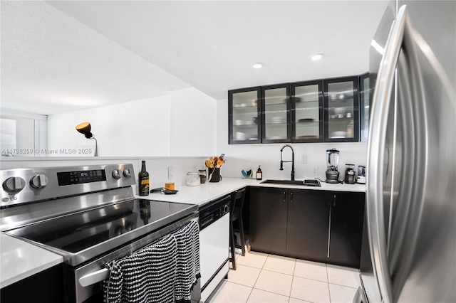 100 NW Bayview Dr Unit 1502, Sunny Isles Beach, FL 33160 - kitchen featuring appliances with stainless steel finishes, light countertops, light tile patterned floors, dark cabinets, and glass insert cabinets