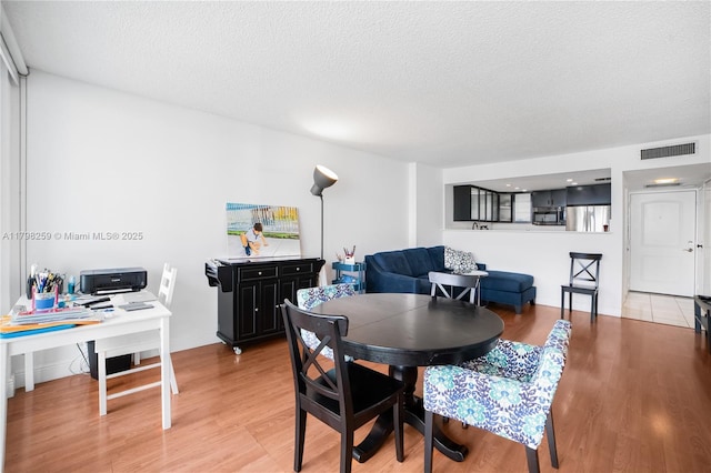 100 NW Bayview Dr Unit 1502, Sunny Isles Beach, FL 33160 - dining room with light wood-style floors and a textured ceiling