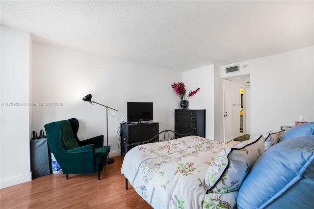 100 NW Bayview Dr Unit 1502, Sunny Isles Beach, FL 33160 - bedroom featuring wood finished floors and a textured ceiling