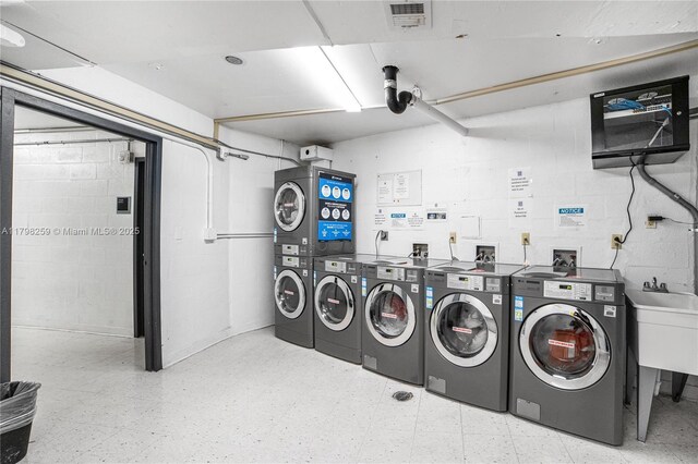 100 NW Bayview Dr Unit 1502, Sunny Isles Beach, FL 33160 - shared laundry with light floors, stacked washer and clothes dryer, washer and dryer, and concrete block wall
