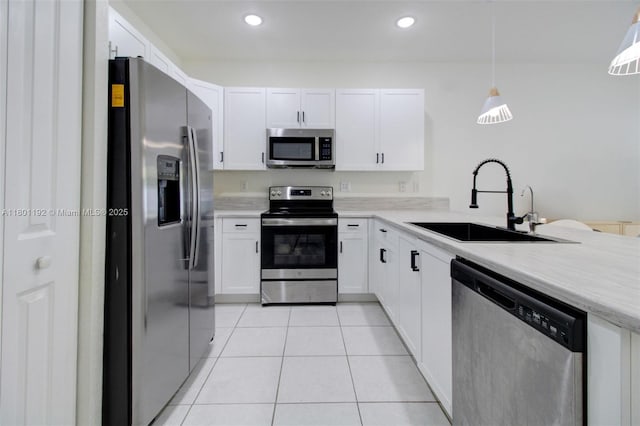 kitchen with stainless steel appliances, a sink, light tile patterned floors, light countertops, and white cabinetry