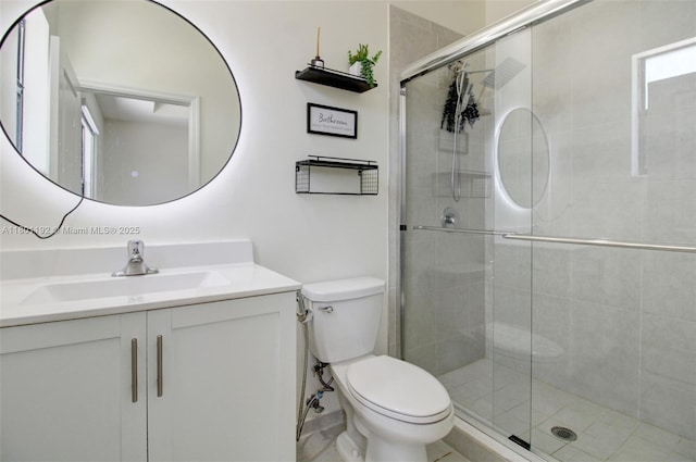 bathroom with toilet, a shower stall, and vanity